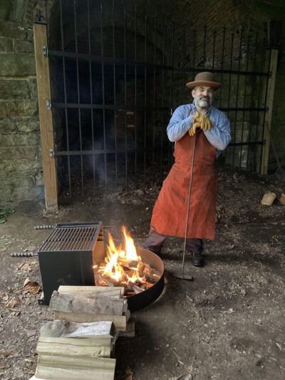 Photo of a volunteer tending the fire at Catoctin Furnace